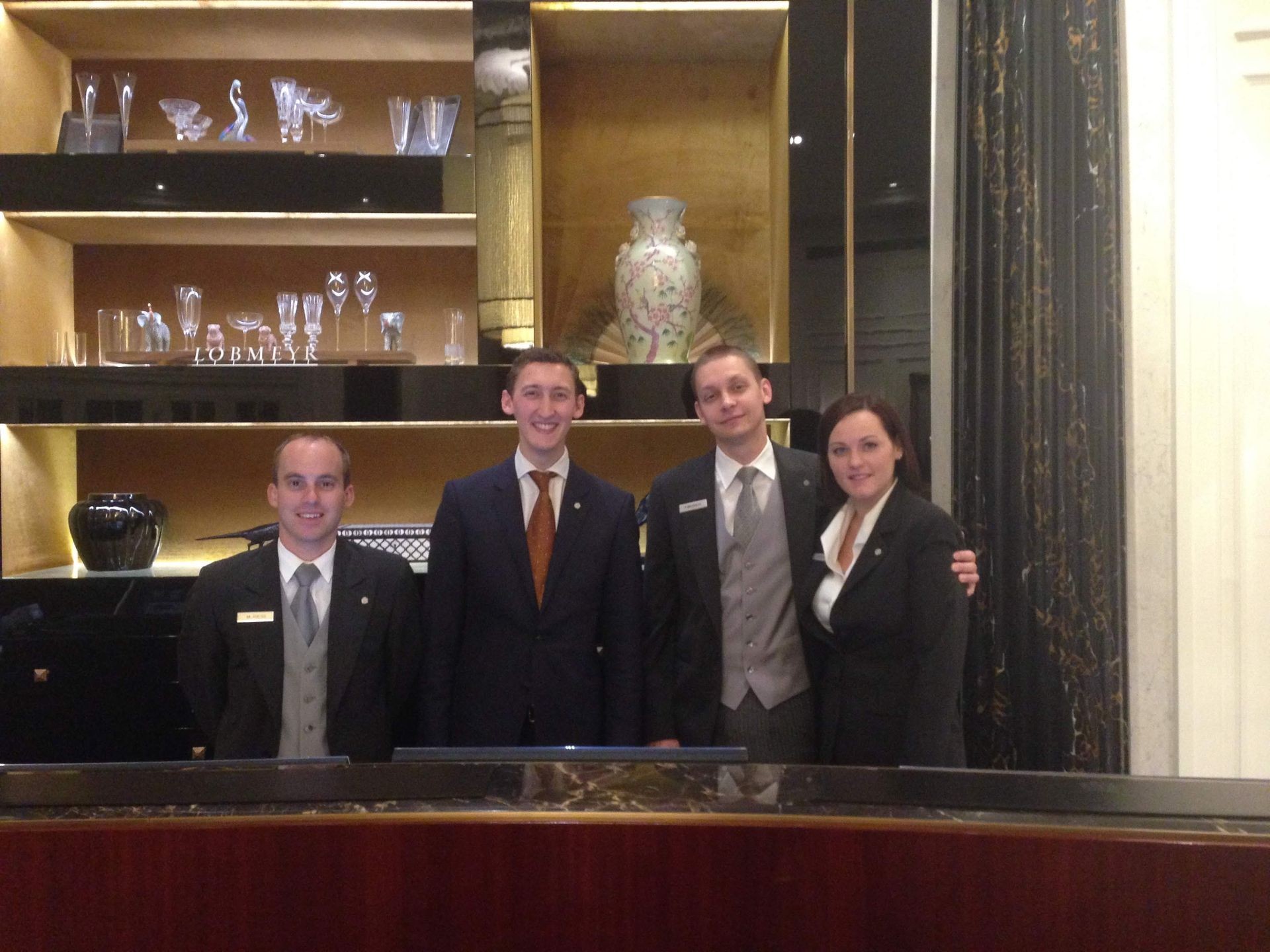A group of hospitality workers standing behind the Reception Desk