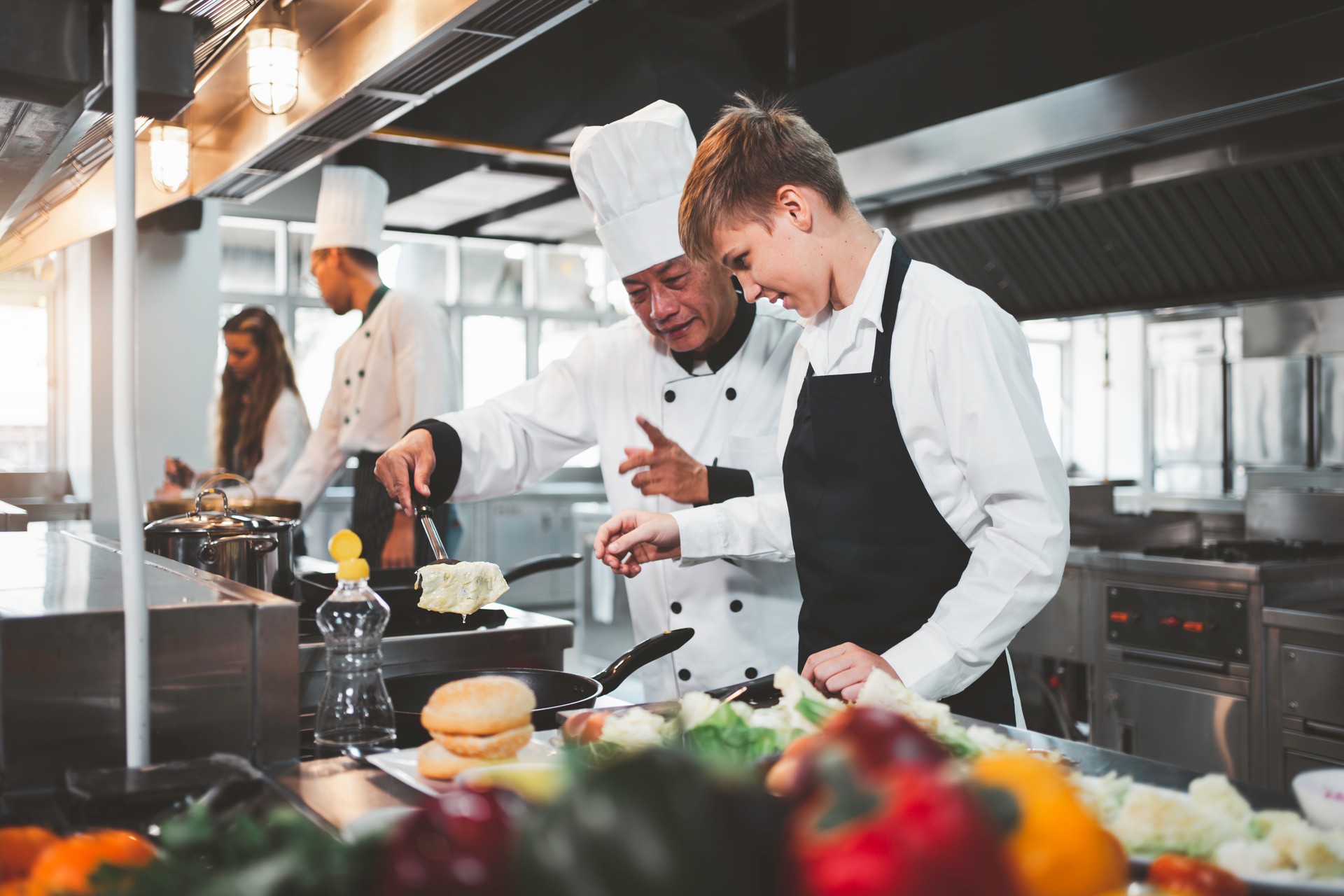 Chef teaching students to cook in the kitchen at a cooking school